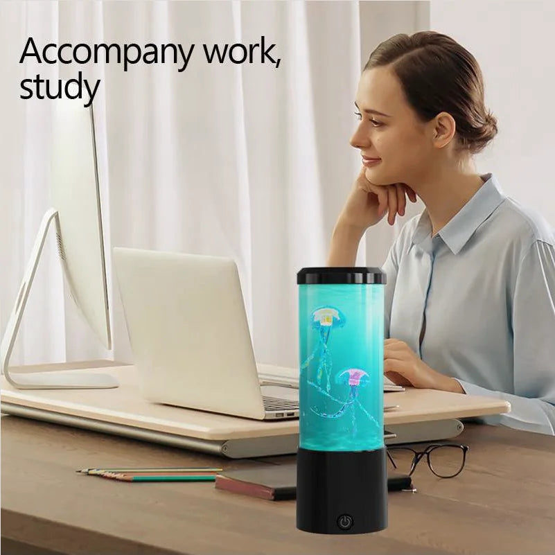 Woman sitting at a desk with a laptop, wearing a jellyfish-themed lamp on the desk.