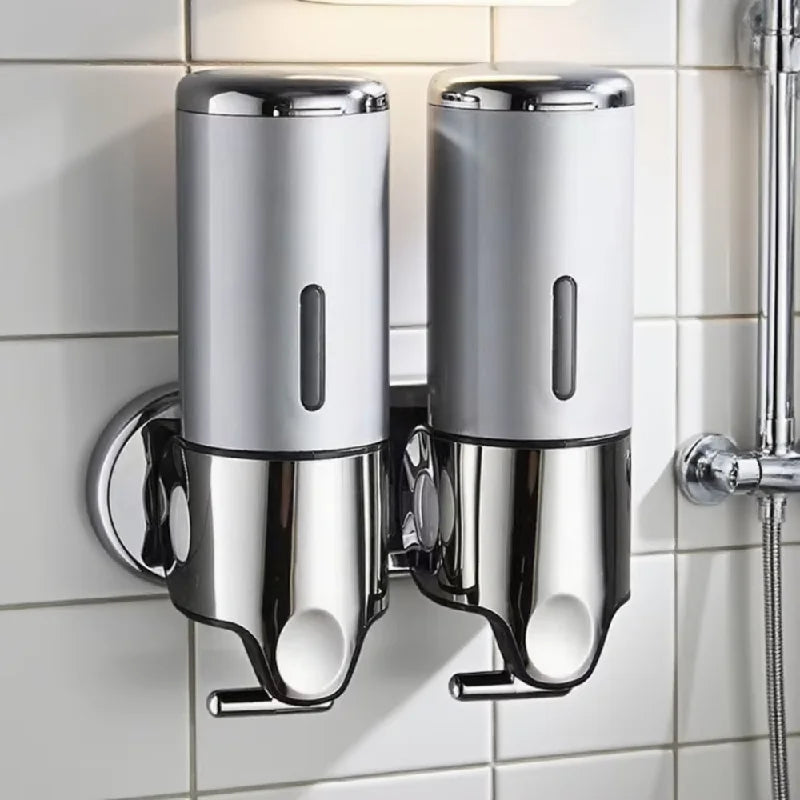 Chrome wall-mounted soap dispenser on a tiled bathroom wall
